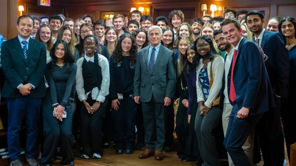 Dr. Fauci stands with a large group of students.