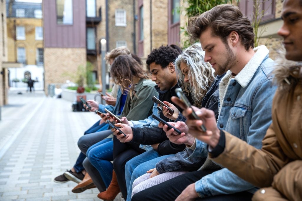 Group of teenage friend focused on their own smartphone texting on social media