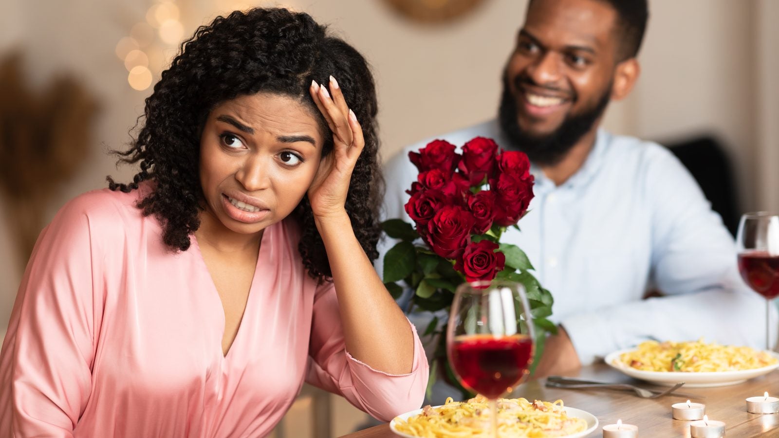 Bad First Impression And Blind Date Concept. Dissatisfied shocked black woman rejecting excited emotional obsessed man who giving her flowers, young couple sitting at table in cafe