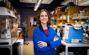 Roussel in a blue la coat in a lab