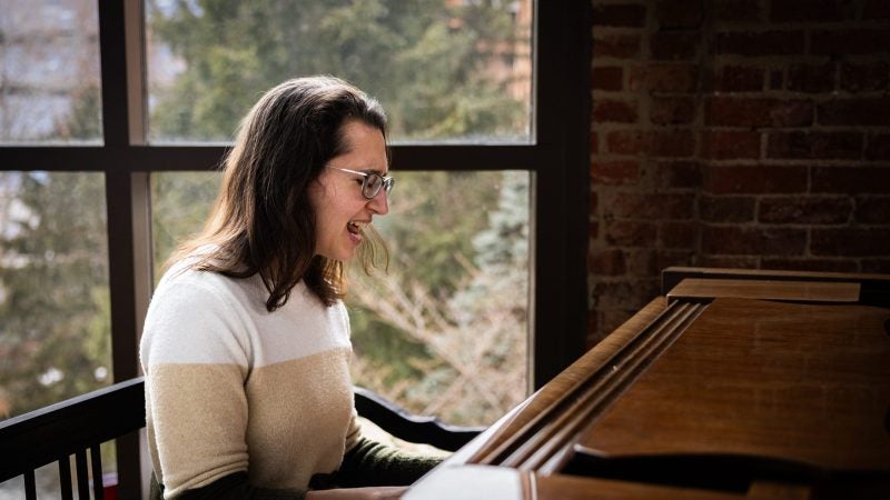 A woman sings while playing the piano.