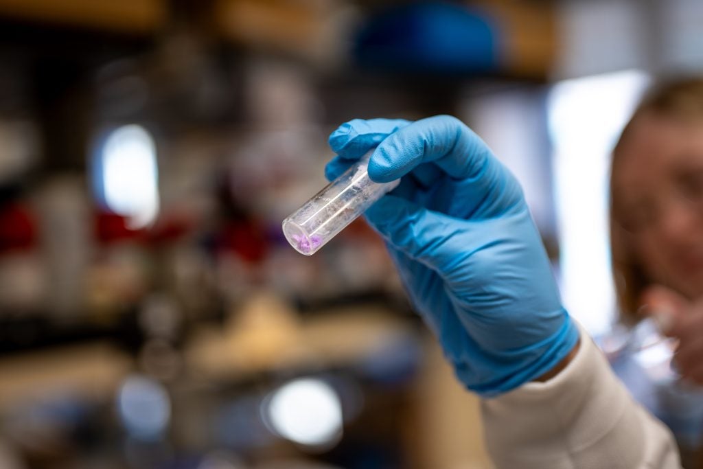 Knope examines a vial in a lab