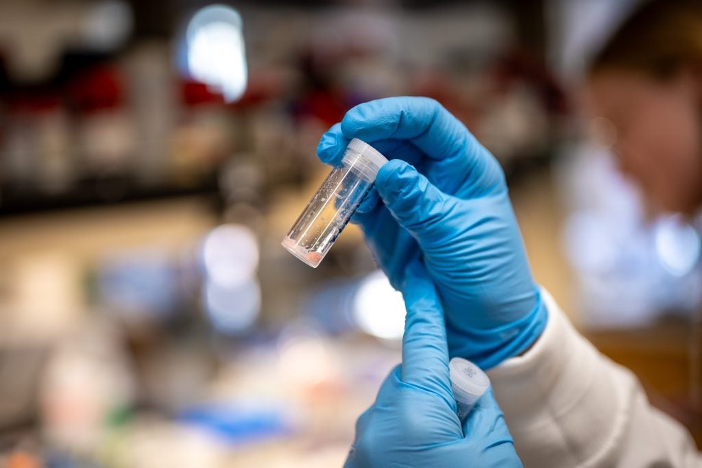 Knope examines a vial in a lab