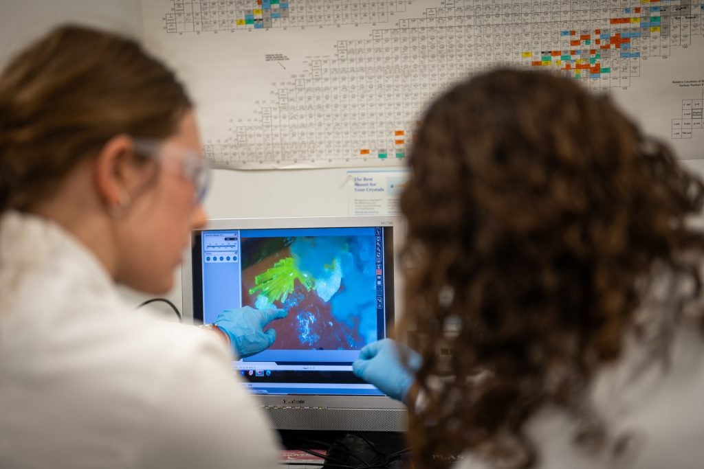 Knope looks at a crystal on a screen with a student