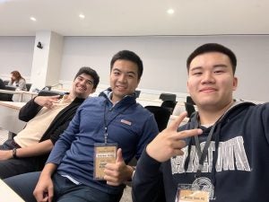 Three young man in a selfie inside a classroom