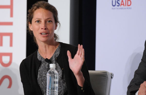 Christy Turlington Burns speaks with left hand raised