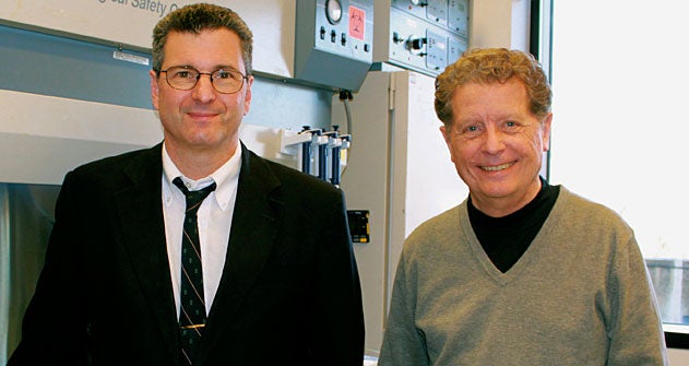 Richard Schlegel and Chris Albanese stand together, smiling, with medical equipment in the background