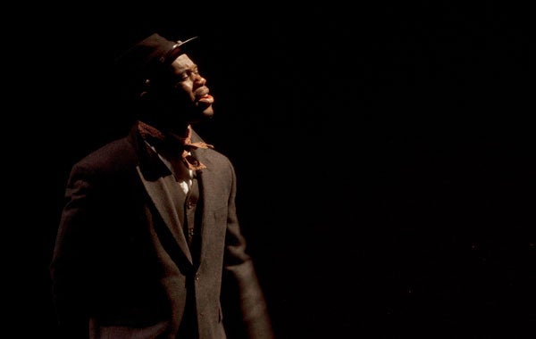 Malik Stevens, dressed in a brown vest and hat, performs in the Davis Performing Arts Center.