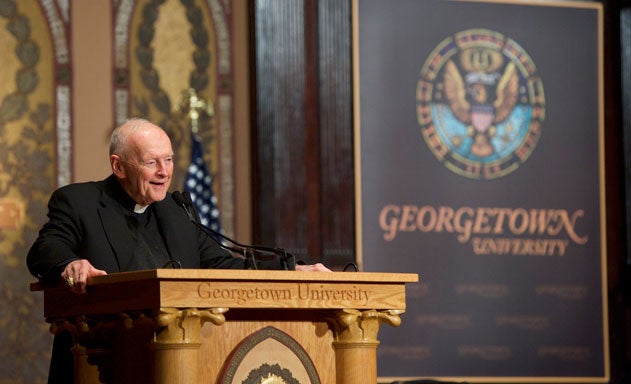 Cardinal Theodore McCarrick, archbishop of Washington emeritus at podium with Georgetown University banner and American flag