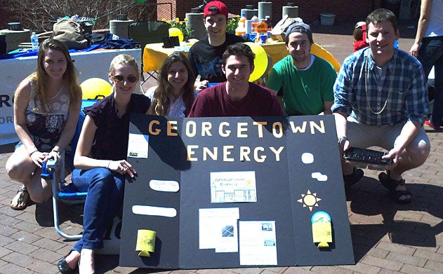 Members of Georgetown Energy pose with poster in Red Square