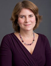 Rosa Brooks, dressed in an eggplant-colored dress, smiles in a headshot.