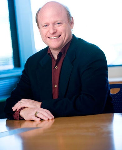 Eric Burger, dressed in a black jacket, smiles for a headshot. 