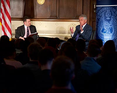 Daniel Byman listens to Chuck Hagel as they have a discussion on stage.