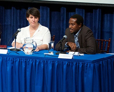 James Habyarimana speaks as Sharon Abramowitz sits to his left.