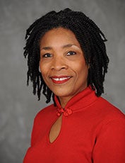 Tawara Goode, in a red top, smiles for the camera in a headshot.