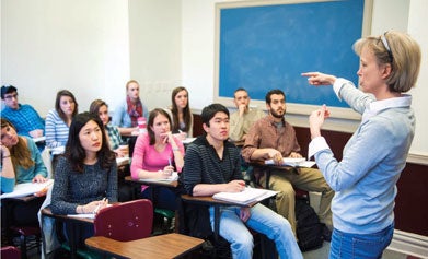 Maggie Little teaches at the front of a classroom.