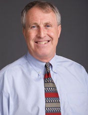 David Koplow, dressed in a striped tie, smiles in a headshot. 