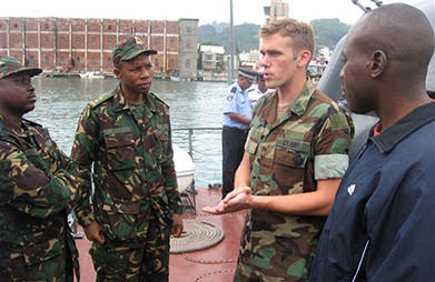 Matthew Gonter stands in military uniform and talks to fellow soldiers.