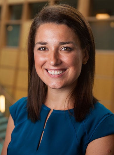 Mary-Hunter McDonnell, in a cobalt blue shirt, smiles for a headshot.