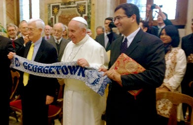 Tom Farr, director of the Religious Freedom Project (RFP) at Georgetown's Berkley Center for Religion, Peace and World Affairs, stands to the left of Pope Francis, as he and Timothy Shah, RFP associate director, hold up a Georgetown scarf with the pontiff.