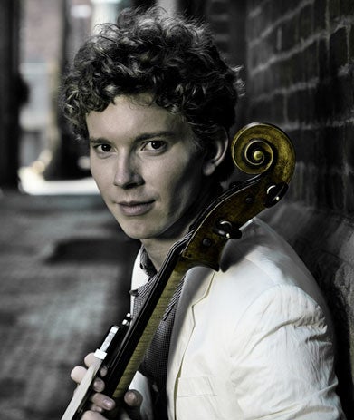 A photo of Joshua Roman, pictured here with his cello.