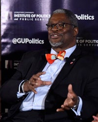 Sly James sits while speaking with a backdrop for GU Politics