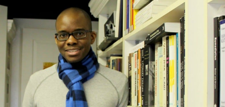 Tope Folarin stands in an office surrounded by books