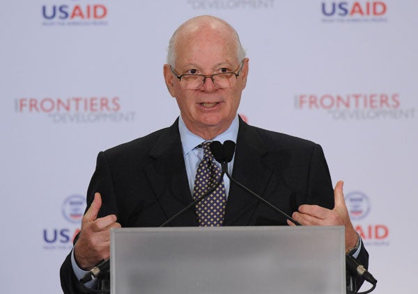 Ben Cardin speaks into a microphone while standing in front of a backdrop