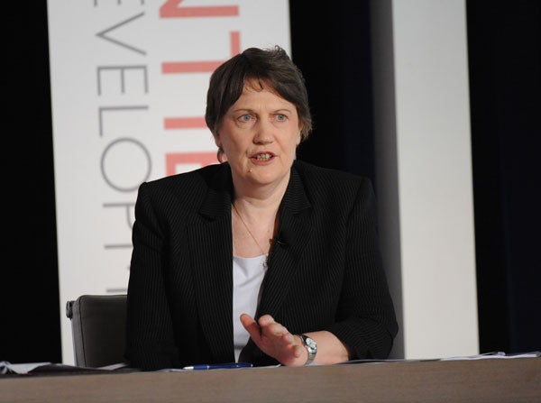 Helen Clark speaks on a panel while seated in front of a backdrop