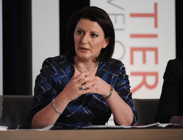 Atifete Jahjaga speaks on a panel while sitting and gesturing with hands