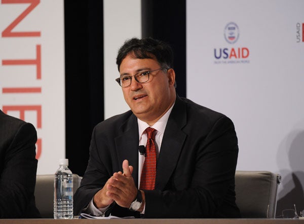 Ariel Pablos-Mendez speaks while seated in front of a backdrop