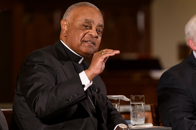 Archbishop Wilton Gregory speaks while he sits on stage.