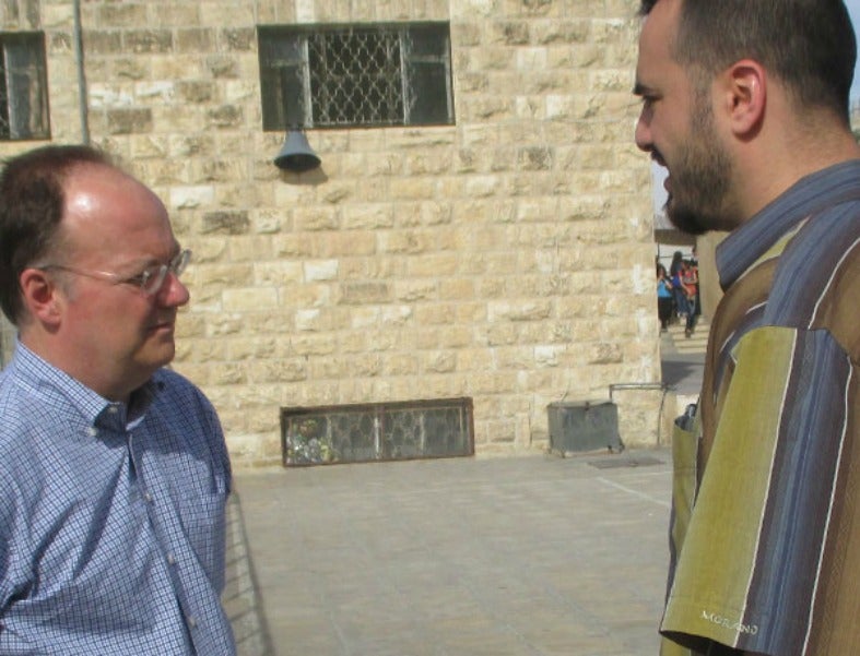 President John J. DeGioia stands outside and talks to Ali Saab