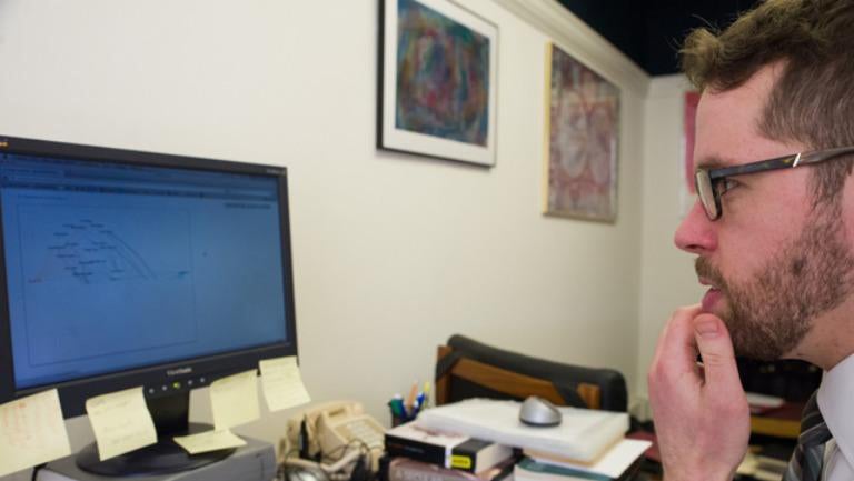 English professor Daniel Shore browses his computer.