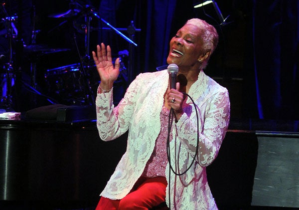 Dionne Warwick sings into microphone on stage at Kennedy Center