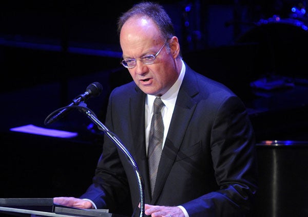 John J. DeGioia speaks at the podium on stage at the Kennedy Center