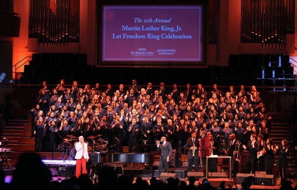 Dionne Warwick and the Let Freedom Ring Choir sing on stage at the Kennedy Center with graphics displayed on screen behind them