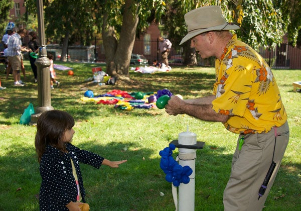 A balloon artist creates a bracelet for Sofia Vereta at the Saturday afternoon picnic.