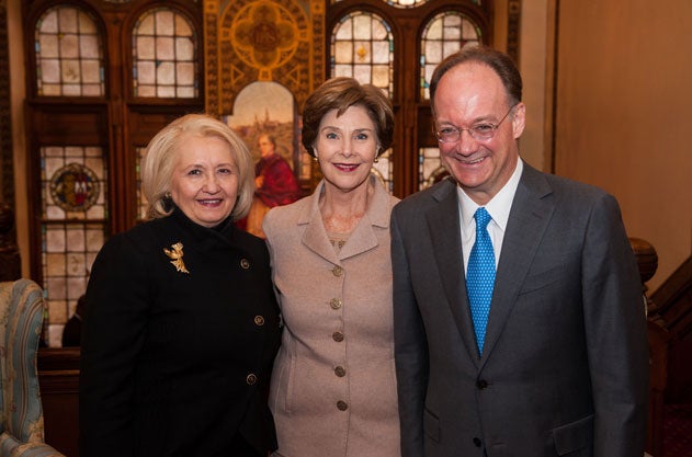 Melanne Verveer, John J. DeGioia and Laura Bush in the Healy Building in front of stained-glass windows