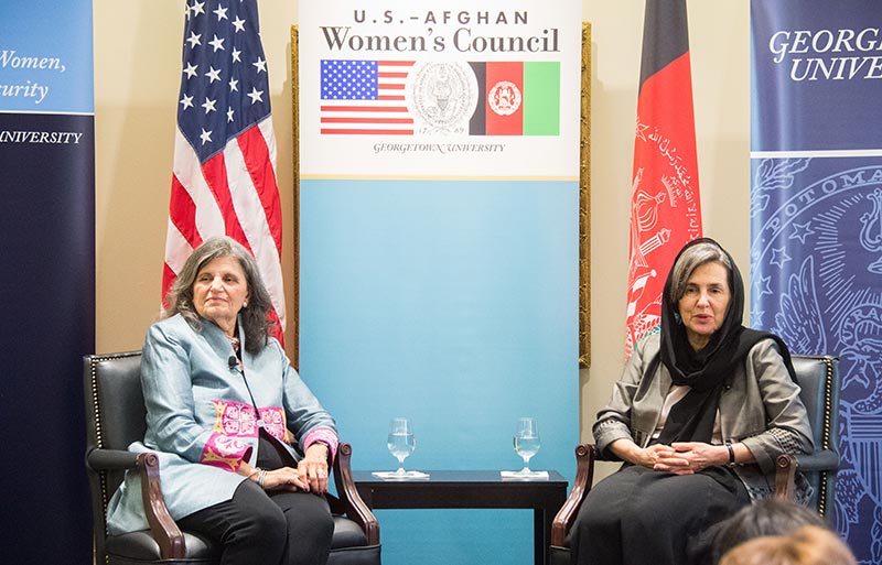 Rula Ghani and Phyllis Magrab sitting with the Afghanistan and American flags and sign reading "U.S.-Afghan Council behind them